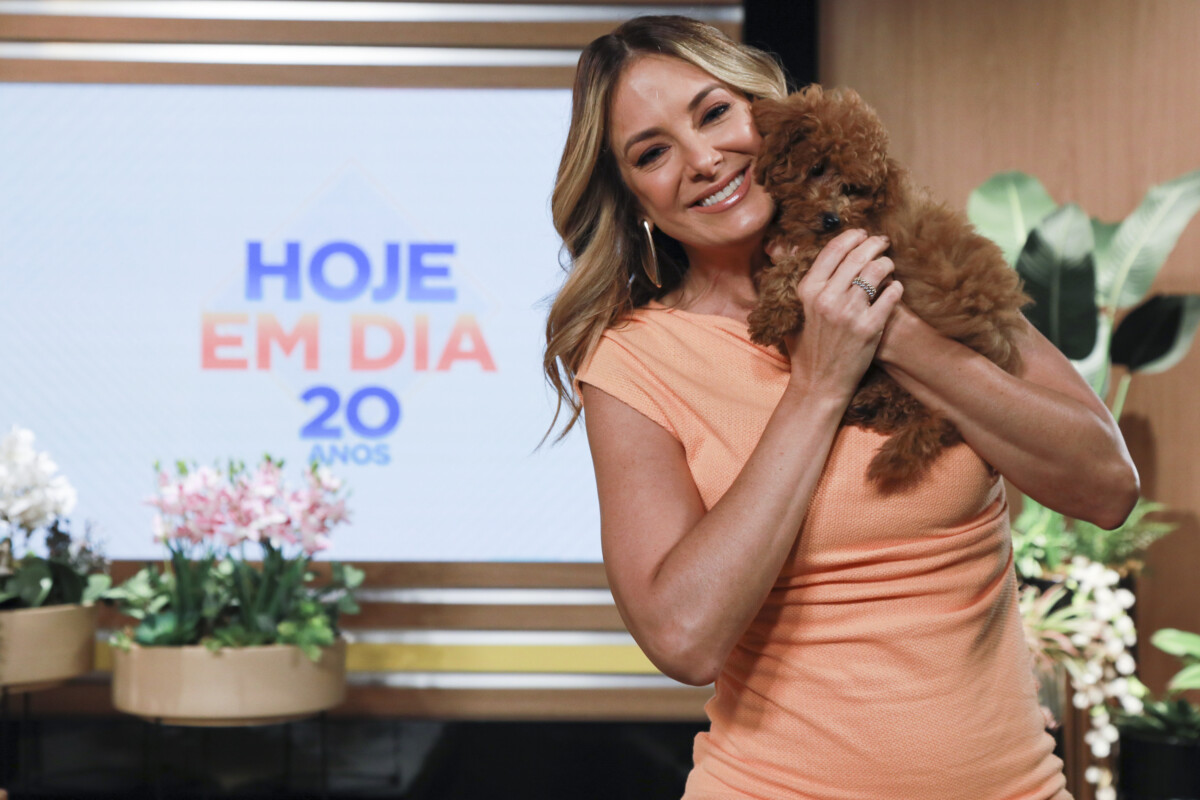 Ticiane Pinheiro segura um cachorro no colo e sorrir no cenário do Hoje em Dia