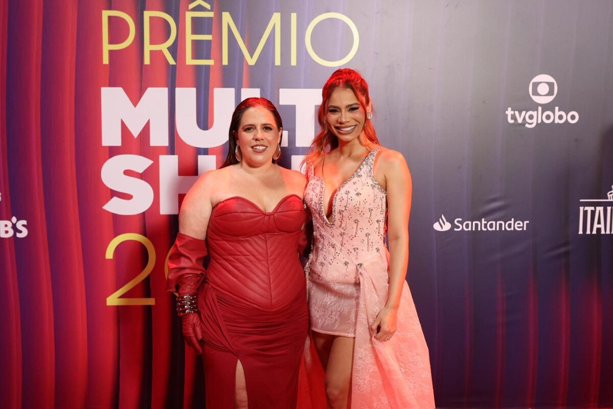 Tati Machado ao lado da cantora Lexa no tapete vermelho dop Prêmio Multishow com seu vestido vermelho